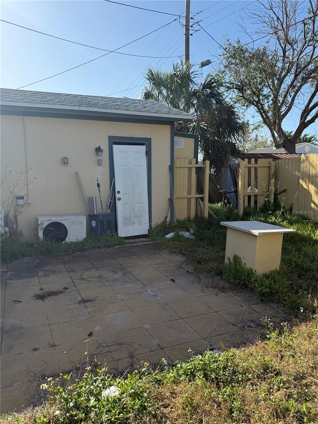 view of outdoor structure with ac unit and fence