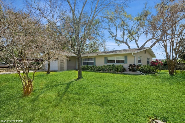 ranch-style house with a garage, a front lawn, and stucco siding