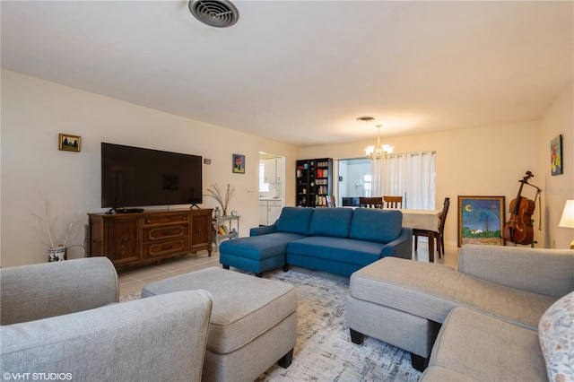 living area with light tile patterned floors, visible vents, and a notable chandelier