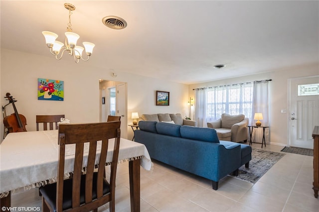 living area with light tile patterned floors, visible vents, and a chandelier