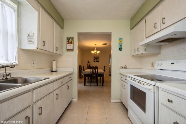 kitchen with light tile patterned floors, light countertops, white electric range, under cabinet range hood, and a sink