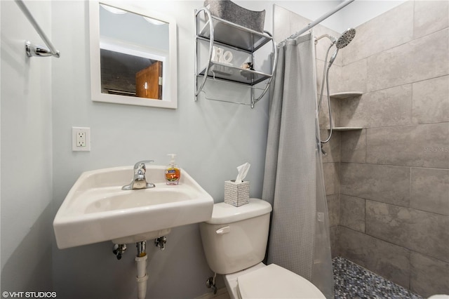 full bath featuring a sink, a shower stall, and toilet