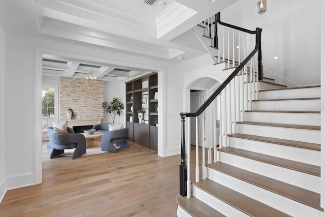 entrance foyer with beam ceiling, stairway, wood finished floors, coffered ceiling, and baseboards