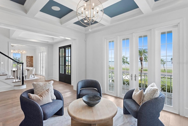 living area featuring a chandelier, wood finished floors, stairs, french doors, and plenty of natural light