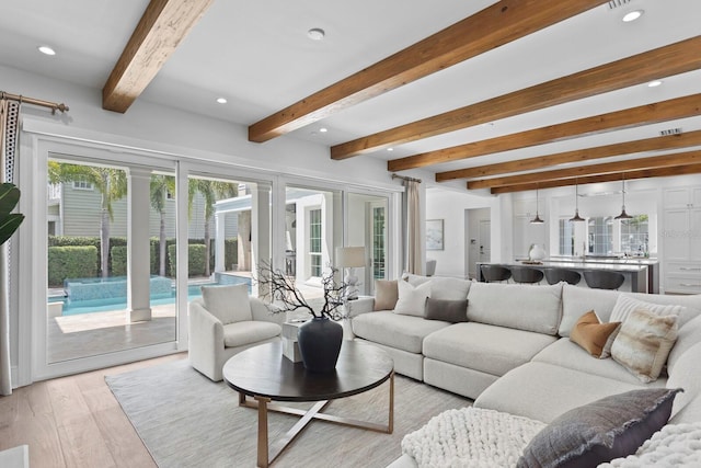 living area featuring light wood finished floors, beamed ceiling, and recessed lighting