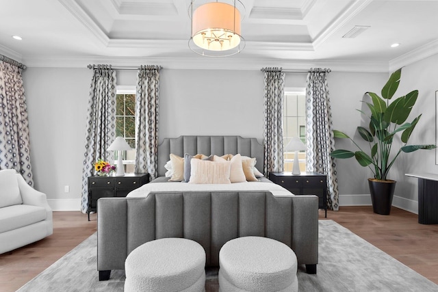 bedroom with ornamental molding, visible vents, baseboards, and wood finished floors