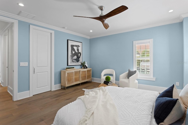 bedroom with ornamental molding, recessed lighting, baseboards, and wood finished floors