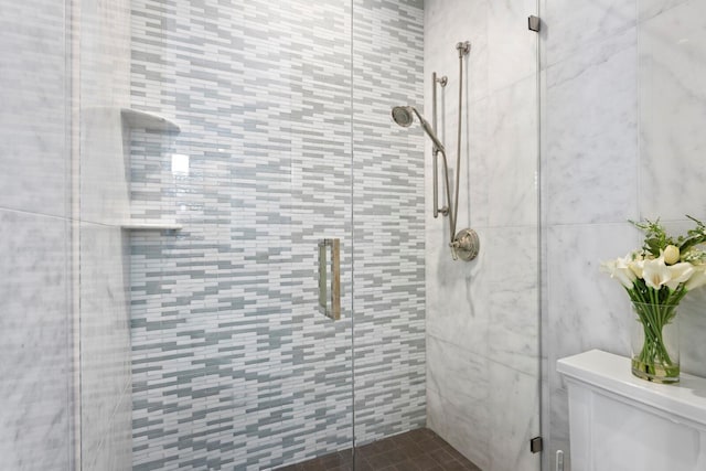 bathroom with toilet and a stall shower