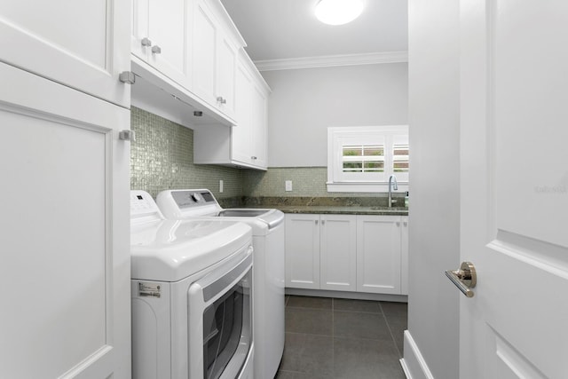 washroom with dark tile patterned flooring, a sink, washer and dryer, cabinet space, and crown molding