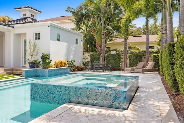 view of pool featuring outdoor dining area, a patio, and an in ground hot tub