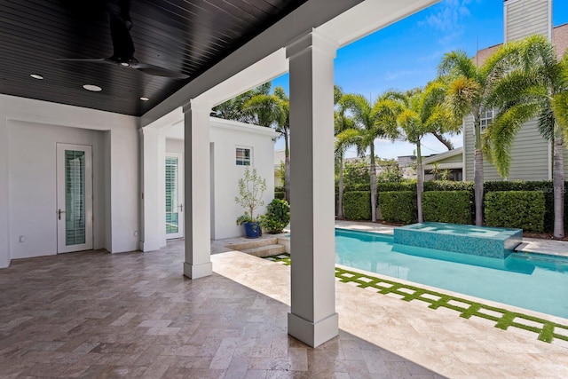 view of swimming pool with a patio area, a pool with connected hot tub, fence, and a ceiling fan