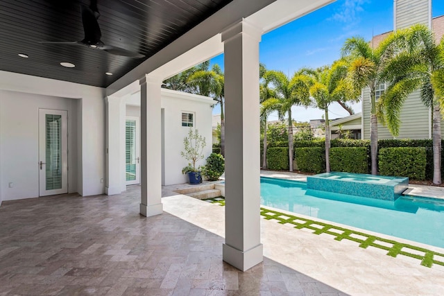 view of swimming pool featuring a pool with connected hot tub, ceiling fan, fence, and a patio