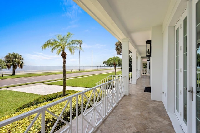 balcony featuring a porch and a water view