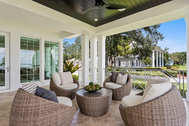 sunroom featuring a ceiling fan, wood ceiling, and decorative columns