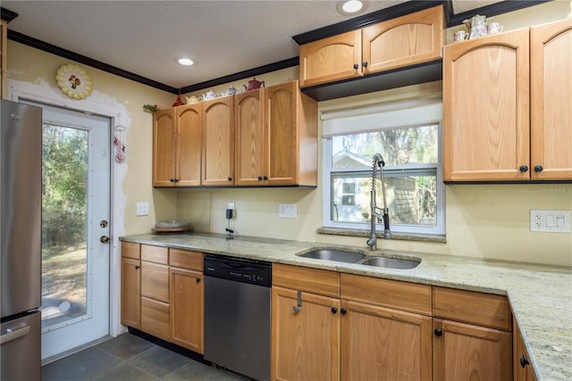 kitchen featuring appliances with stainless steel finishes, plenty of natural light, a sink, and light stone counters