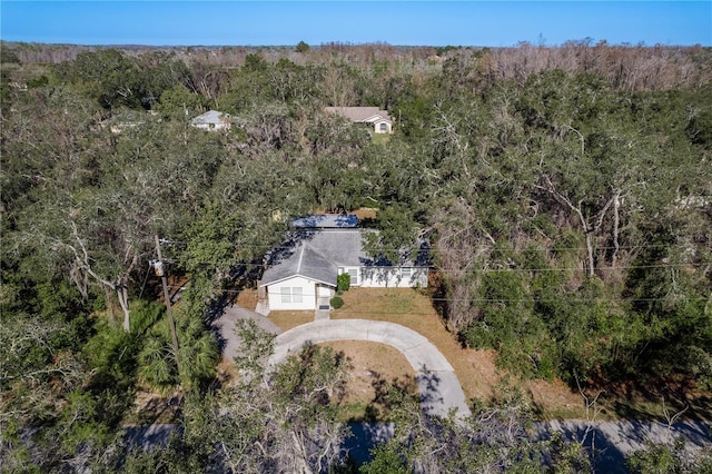 bird's eye view with a wooded view