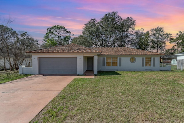 ranch-style home with an attached garage, a tile roof, driveway, stucco siding, and a front lawn