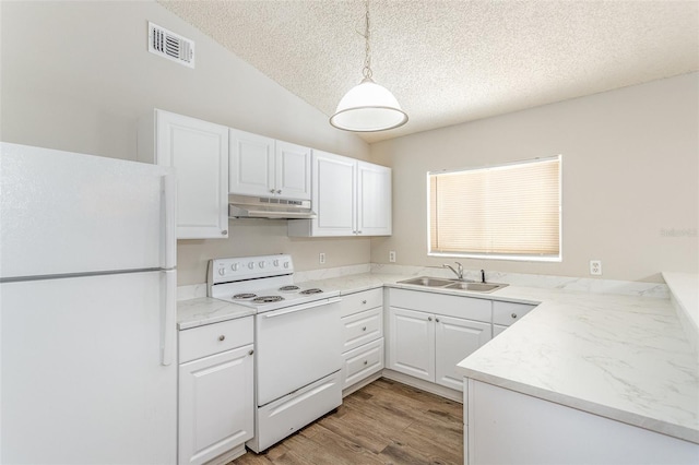 kitchen featuring visible vents, white cabinetry, a sink, white appliances, and under cabinet range hood