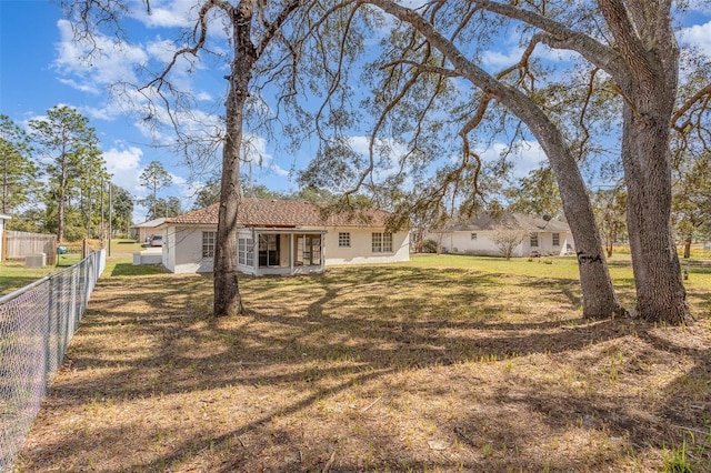 view of front of home featuring fence, a patio, a front lawn, and stucco siding