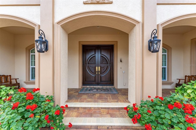 entrance to property with covered porch and stucco siding