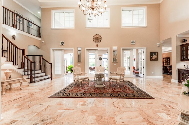 entryway featuring marble finish floor, a notable chandelier, crown molding, stairway, and baseboards