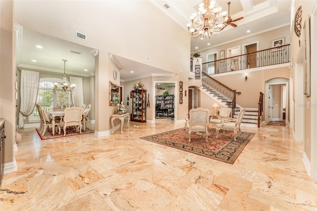 foyer entrance with arched walkways, visible vents, an inviting chandelier, baseboards, and stairs