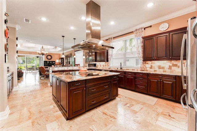 kitchen with plenty of natural light, island range hood, freestanding refrigerator, a peninsula, and crown molding