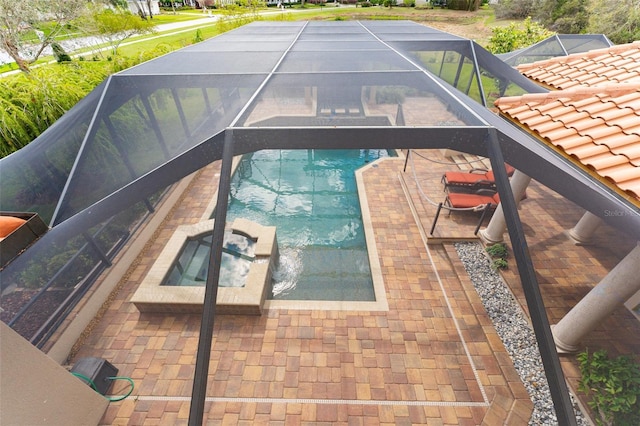 view of swimming pool featuring a patio area, a lanai, and a pool with connected hot tub