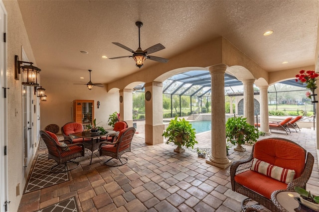 view of patio / terrace with an outdoor pool, a lanai, and ceiling fan