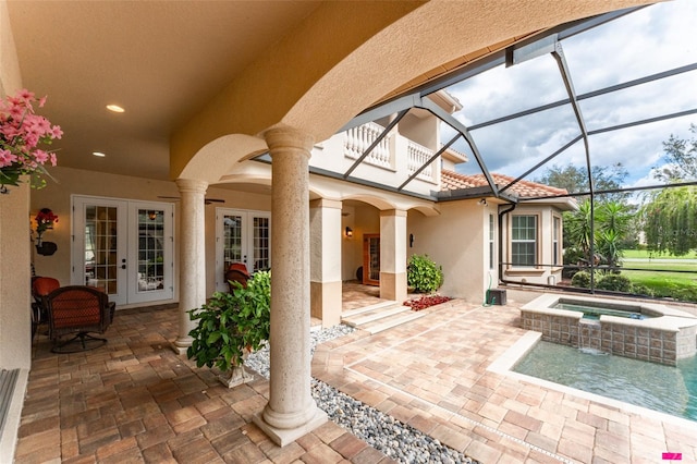 view of patio featuring a lanai, an in ground hot tub, and french doors