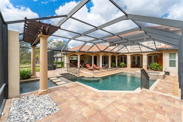 view of swimming pool featuring a patio area, a pool with connected hot tub, and glass enclosure