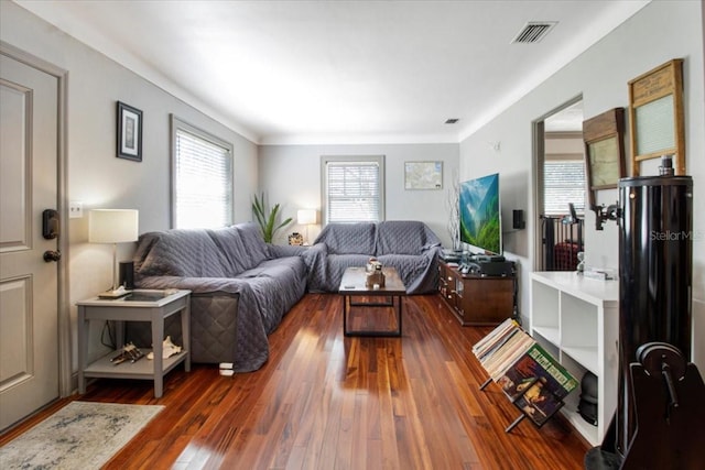 living room with hardwood / wood-style flooring and visible vents