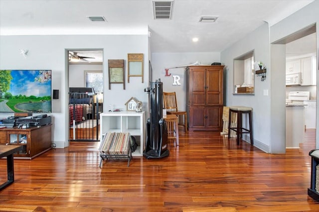 foyer entrance with wood finished floors, visible vents, and a ceiling fan