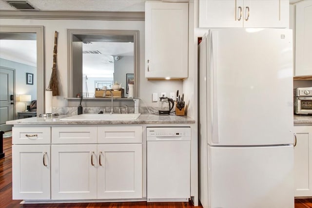 kitchen featuring visible vents, ornamental molding, white cabinets, a sink, and white appliances