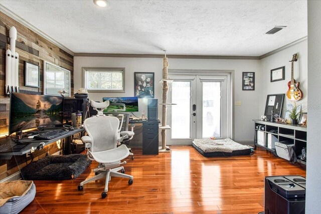 home office with french doors, crown molding, visible vents, a textured ceiling, and wood finished floors