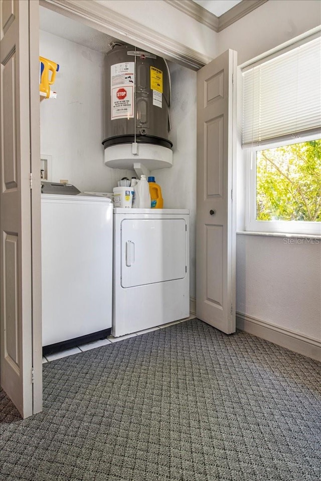 clothes washing area with baseboards, water heater, ornamental molding, carpet, and washing machine and clothes dryer