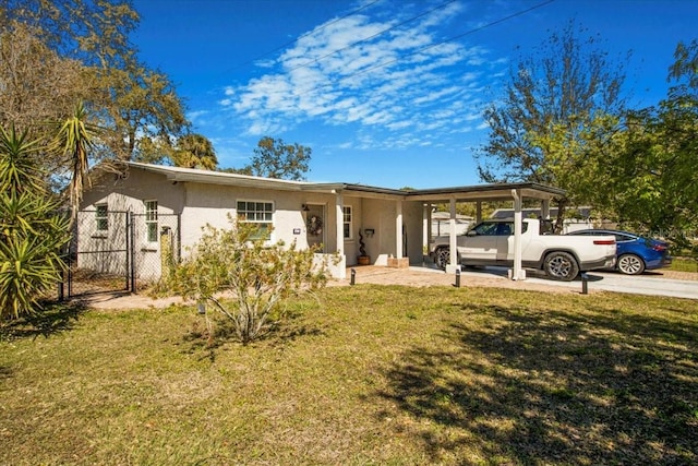 view of front of property with an attached carport, a gate, a front lawn, and stucco siding