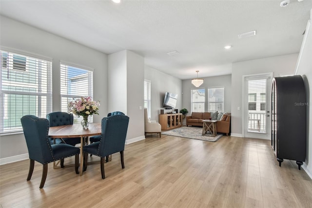 dining room with visible vents, baseboards, and light wood-style floors