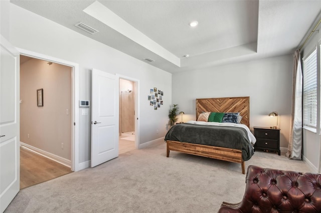 bedroom with a raised ceiling, carpet flooring, baseboards, and visible vents