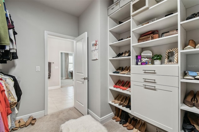 spacious closet featuring light tile patterned floors and light carpet