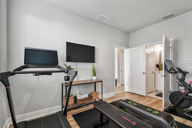 exercise area featuring visible vents, baseboards, and light wood-style flooring