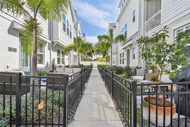 view of home's community with outdoor lounge area, fence, and a residential view