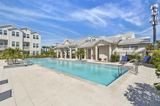 community pool with fence and a patio