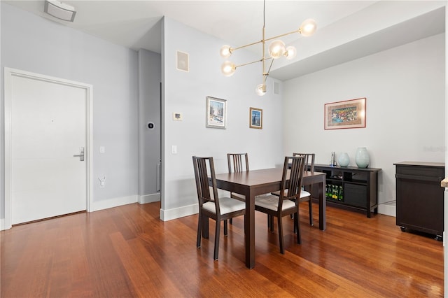 dining area with an inviting chandelier, visible vents, baseboards, and wood finished floors