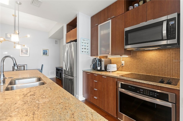 kitchen featuring tasteful backsplash, visible vents, modern cabinets, stainless steel appliances, and a sink