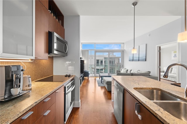 kitchen featuring appliances with stainless steel finishes, brown cabinets, a sink, and modern cabinets