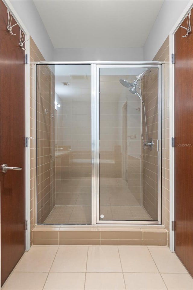 full bath with a stall shower and tile patterned flooring