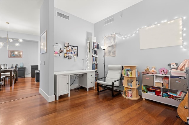 interior space with a notable chandelier, baseboards, visible vents, and wood finished floors