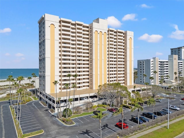 view of property with a view of city, uncovered parking, and a water view