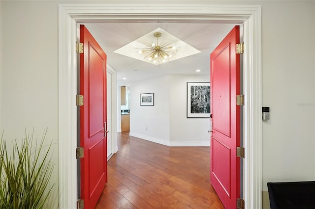 hallway featuring recessed lighting, baseboards, wood-type flooring, and a chandelier